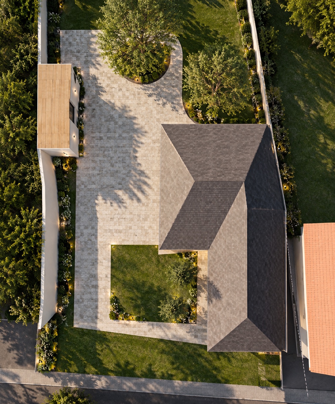 Bird's-eye view of the plot: the L-shaped house at the east, a paved drive around a large tree, lawn and hedges